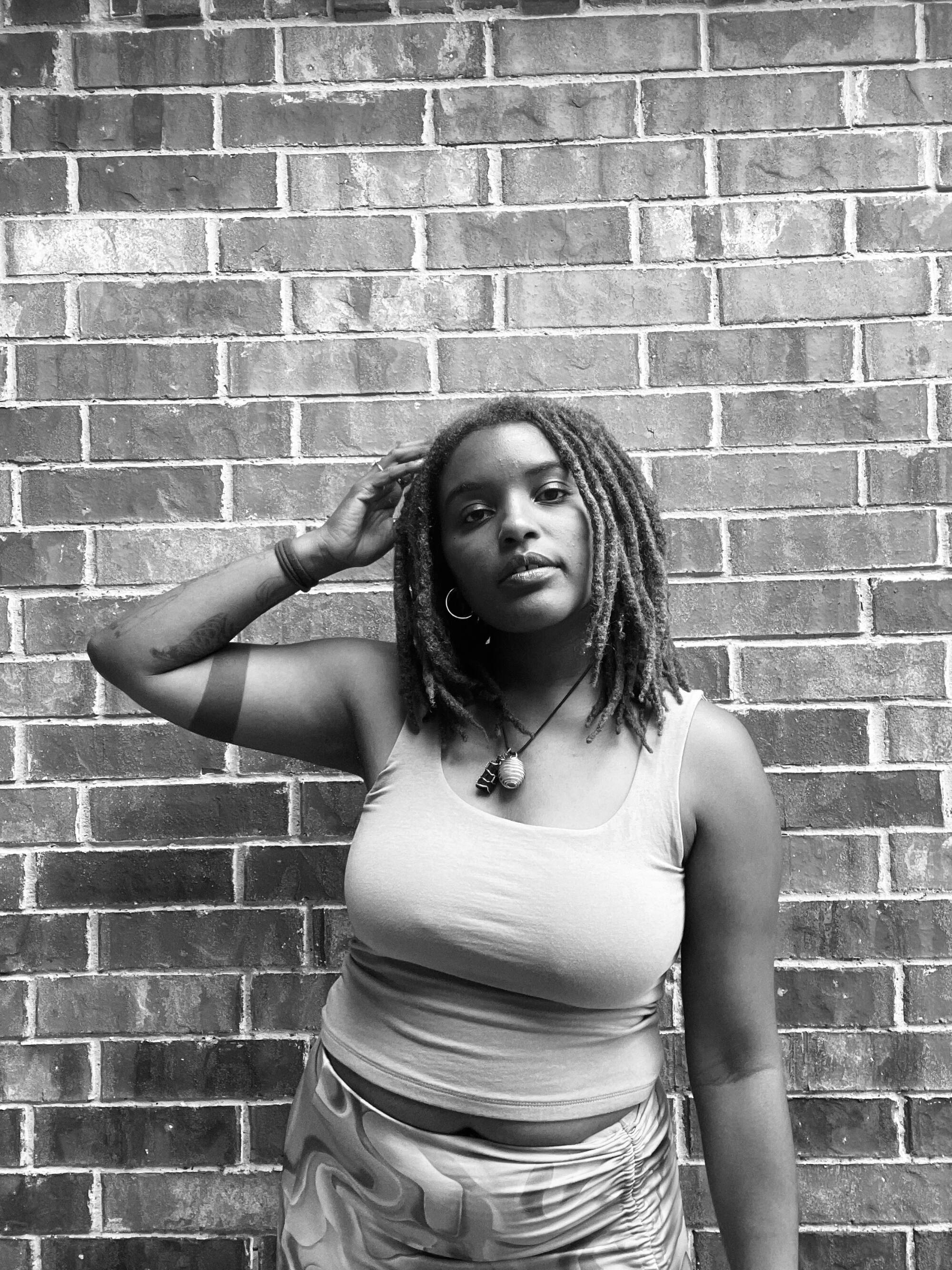 Kenda Allen poses in front of a brick wall.